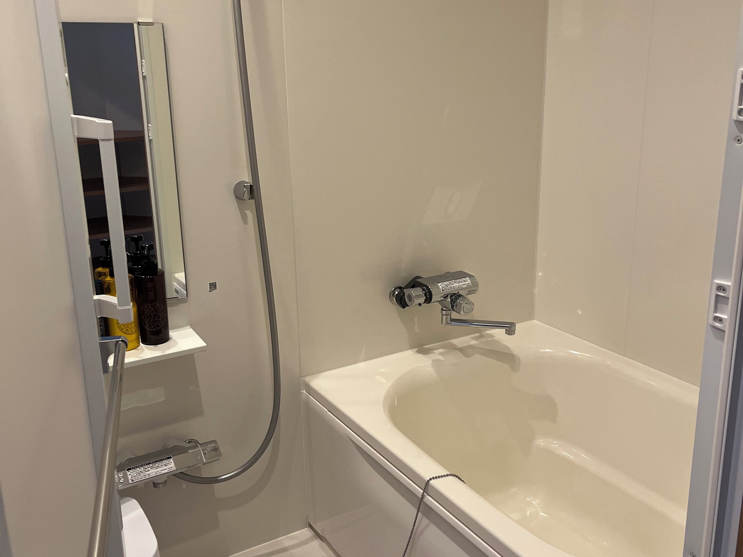 A modern bathroom with a bathtub, a showerhead, and a toilet.