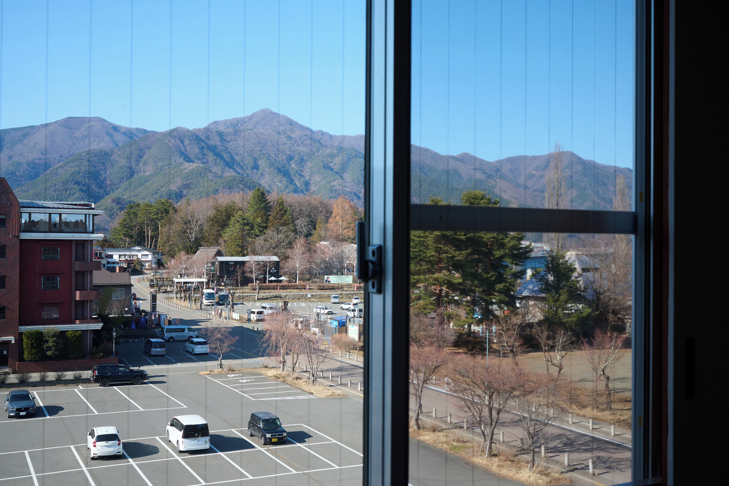 A parking lot with vehicles and a mountain view in the background.