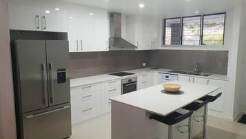 Een koelkast met diepvriezer, een microgolfoven, een oven, een kookplaat