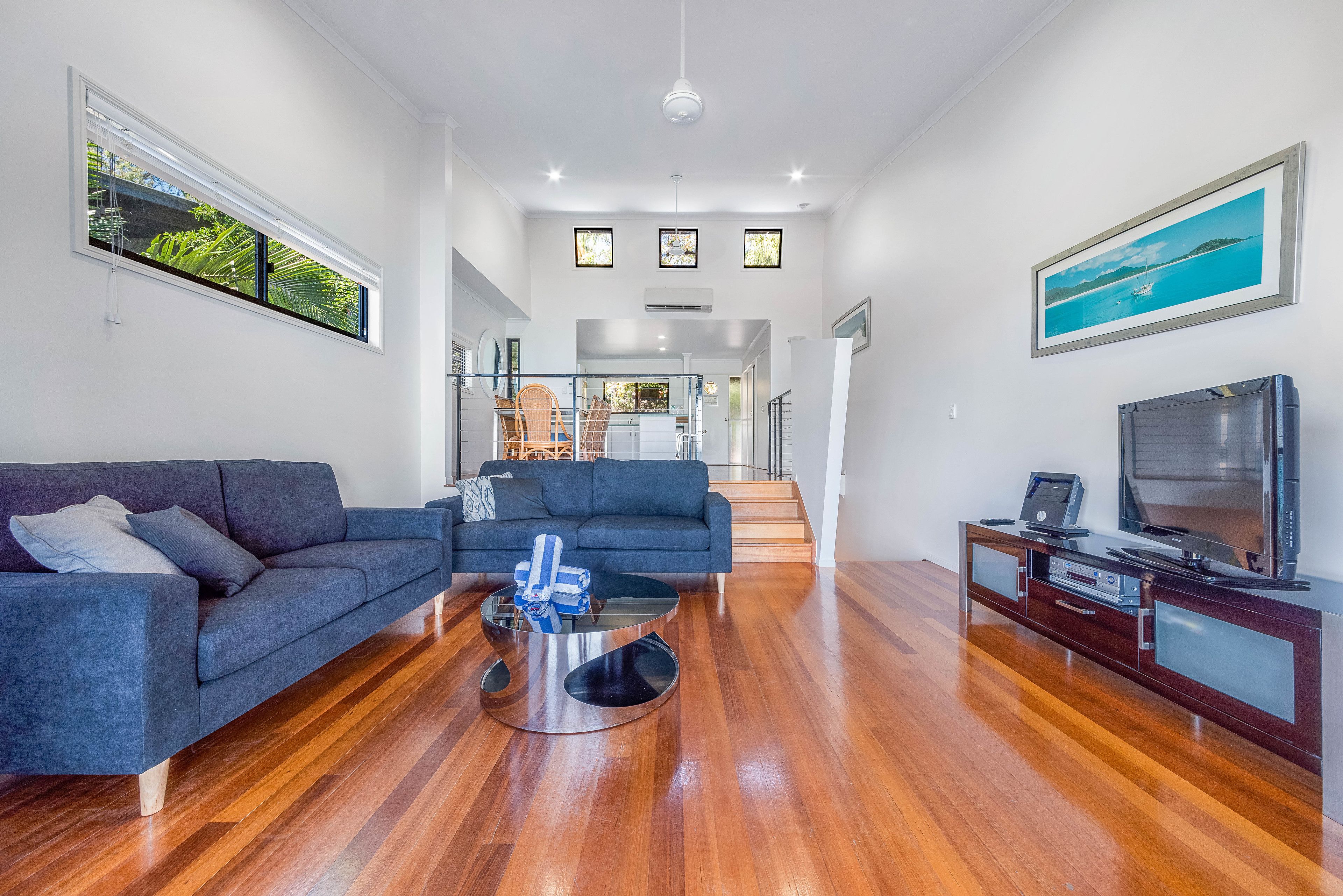 A spacious living room with a sofa, a coffee table, and a TV stand.