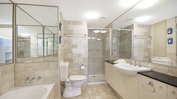 A modern bathroom with a bathtub, toilet, and shower area.