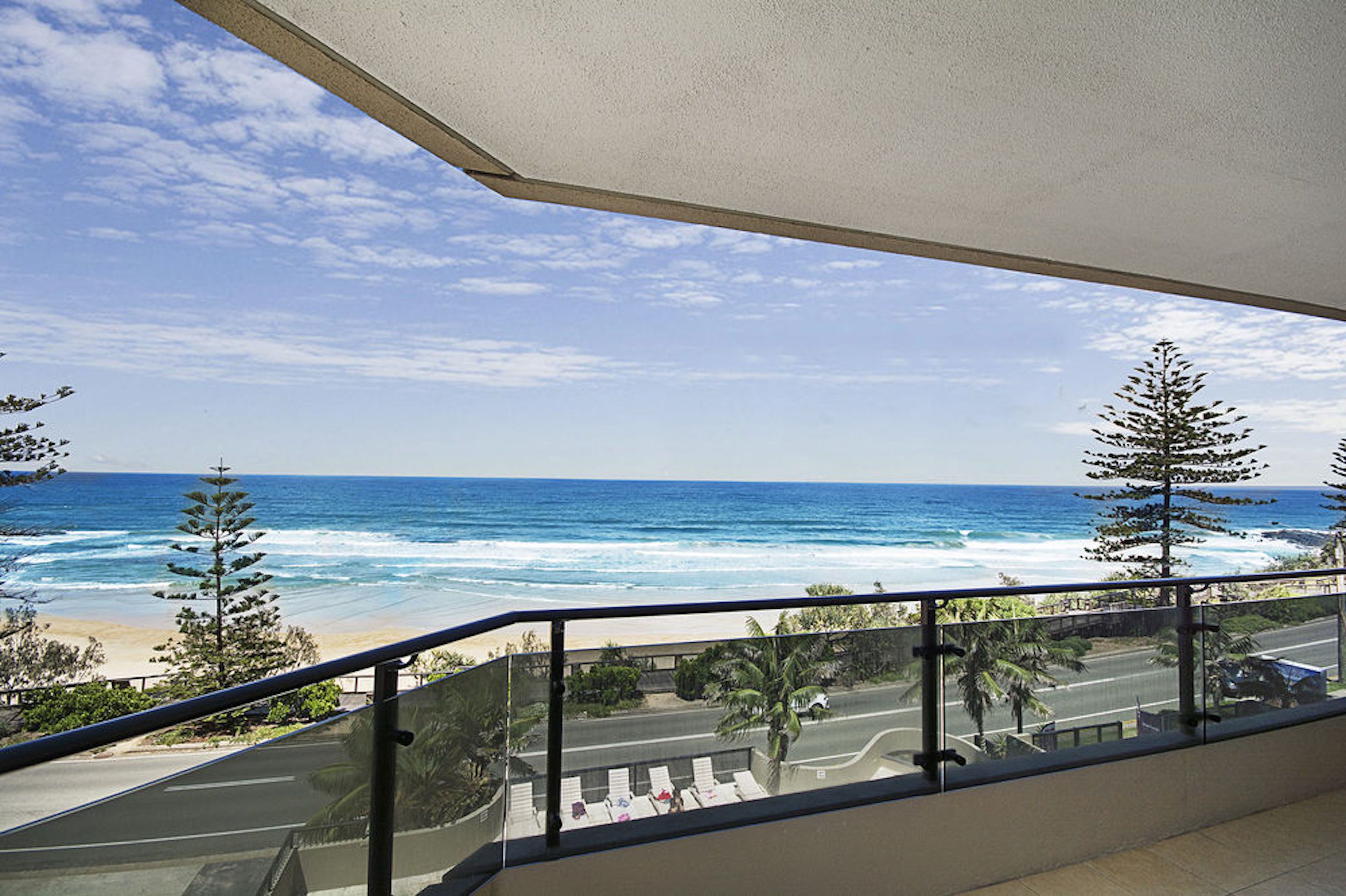 A balcony with a view of the ocean and beach.