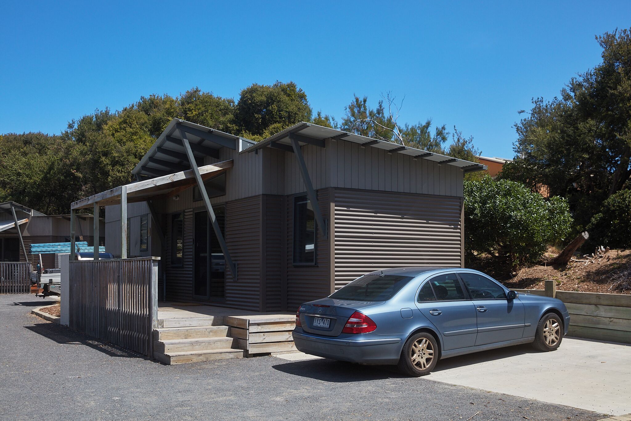 A modern two-story building with a garage and a car parked in front.