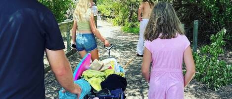 A pathway with a stroller and people walking.