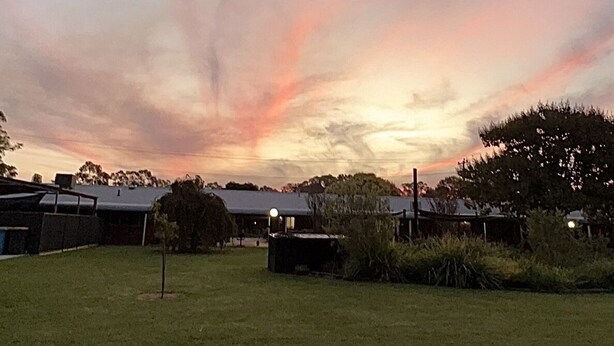 A grassy area with a building in the background. - Greenways Holiday Units (Tocumwal)
