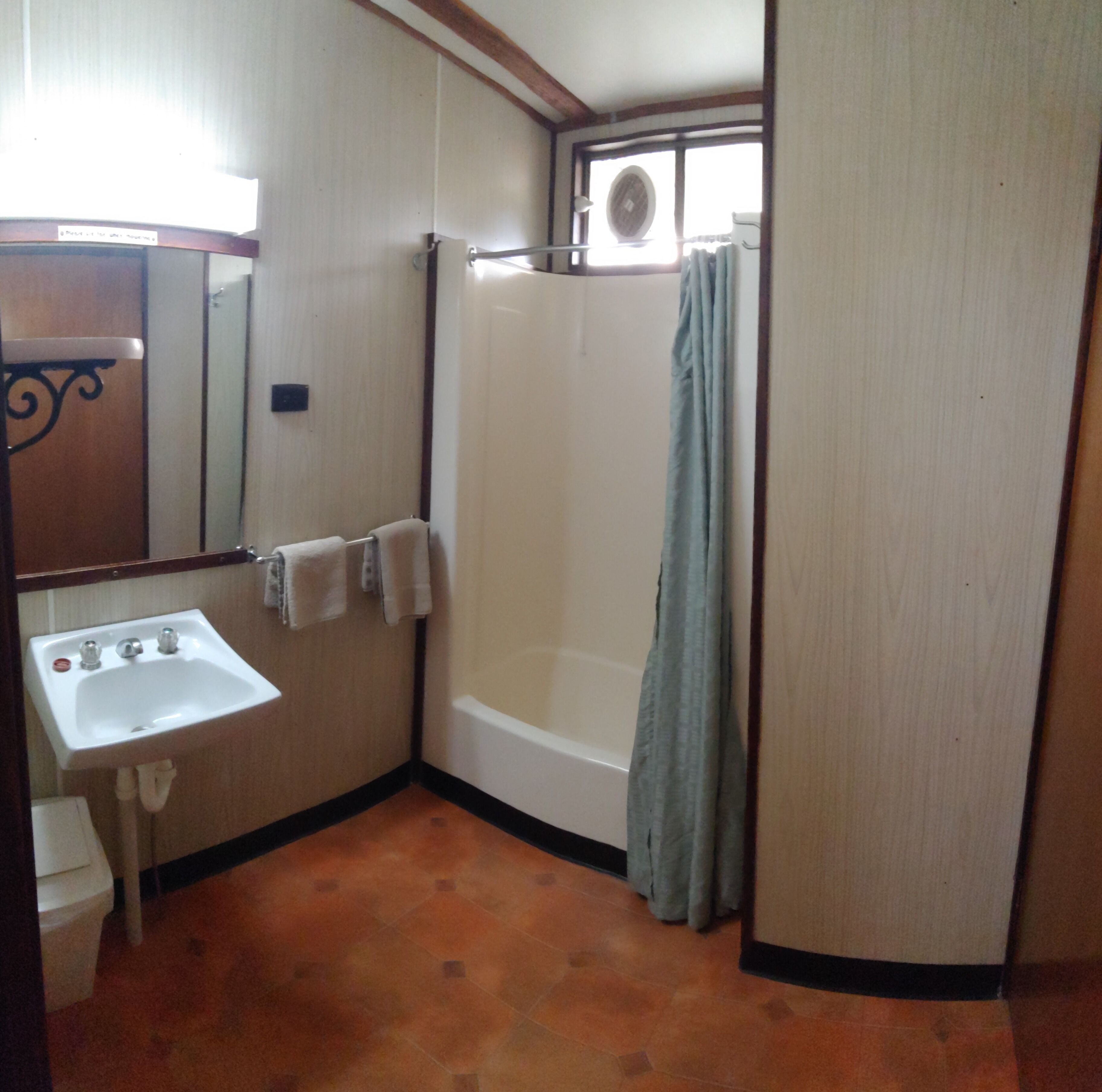A bathroom with a sink, a bathtub, and a shower curtain.