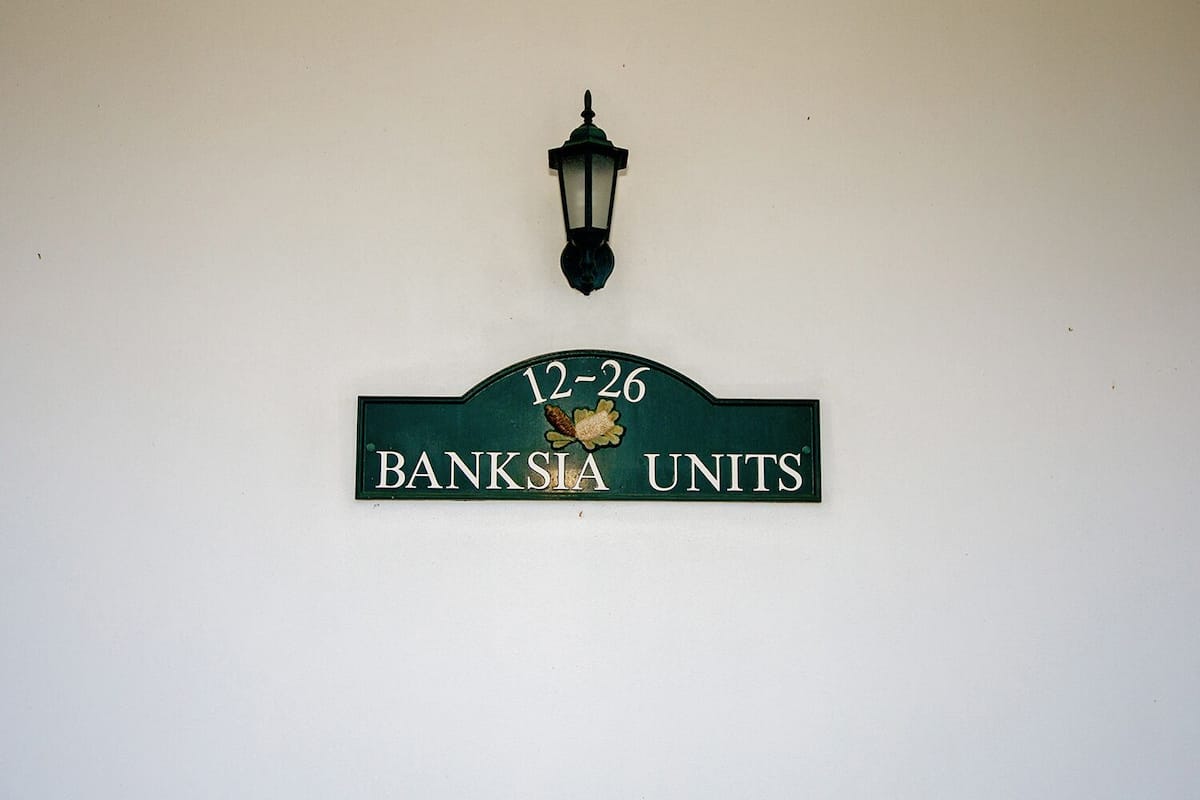 A sign with the text "12-26 BANKSIYA UNITS" and a decorative lamp above it.