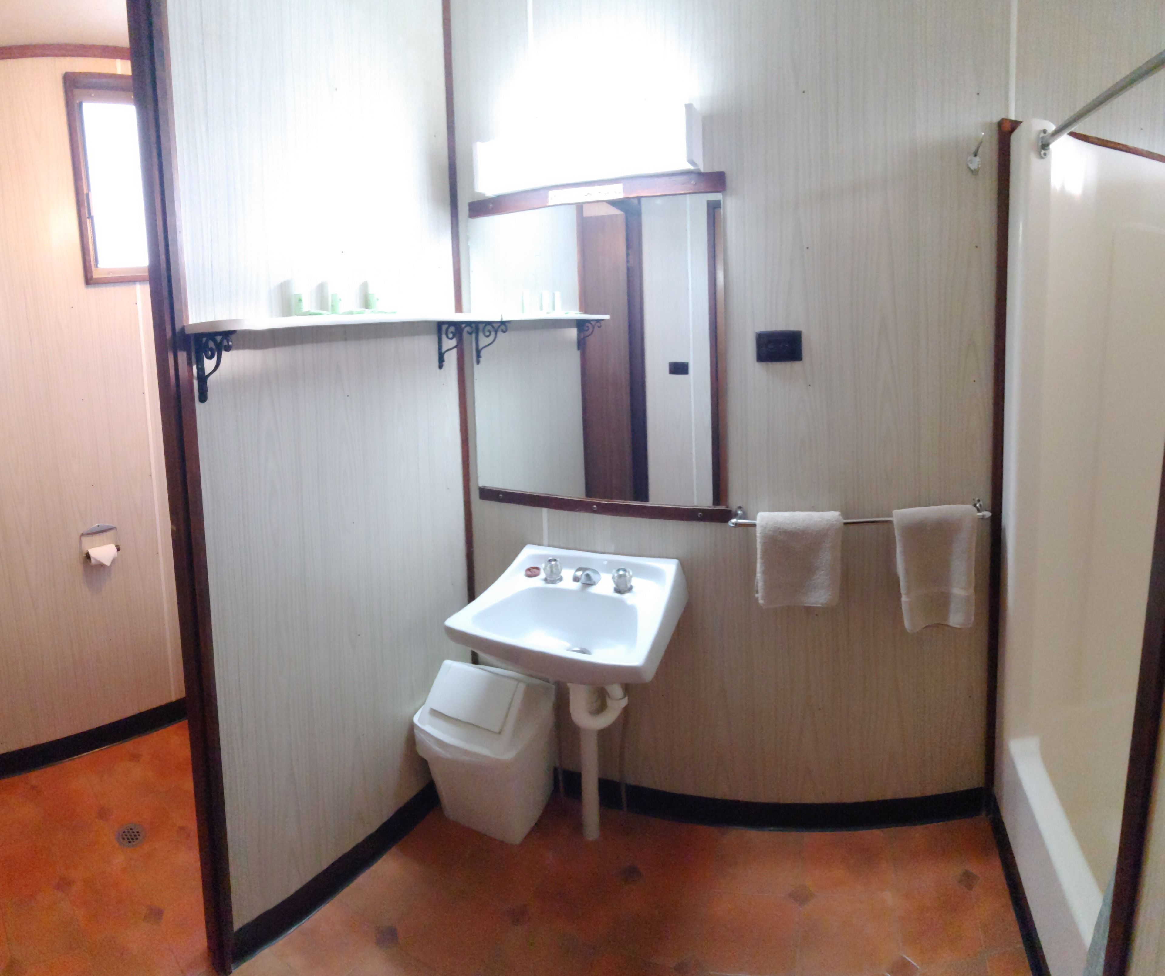 A bathroom with a sink, mirror, towel rack, and toilet.