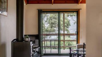 A room with a fireplace, a sliding glass door to an outdoor deck, and a small table with chairs.