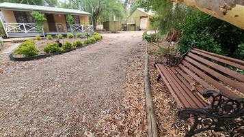 Sit and relax in a serene outdoor space surrounded by trees and a small garden.