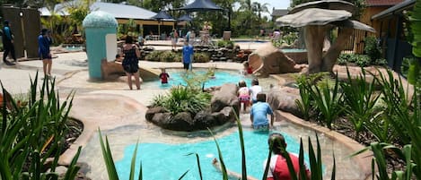 Una piscina al aire libre, sillones reclinables de piscina