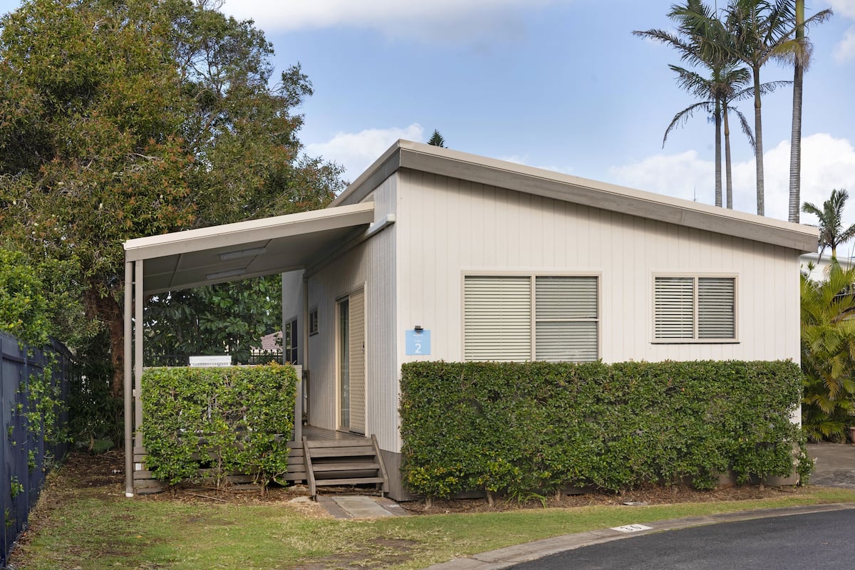 A single-story building with a covered entrance, a small porch, and a number '2' sign.