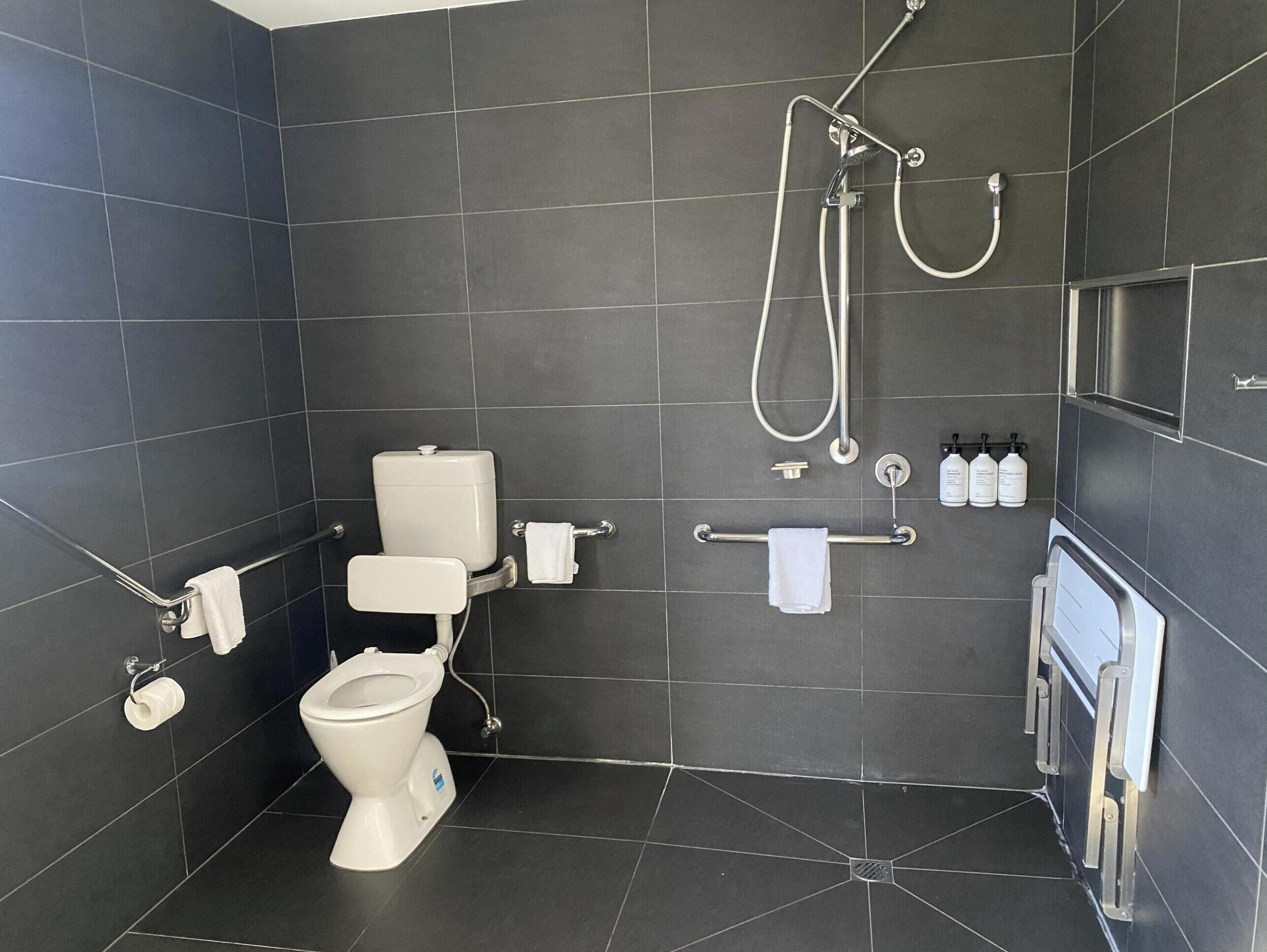 A modern bathroom with a toilet, bidet, and shower.