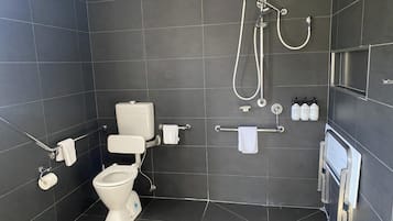 A modern bathroom with a toilet, bidet, and shower.