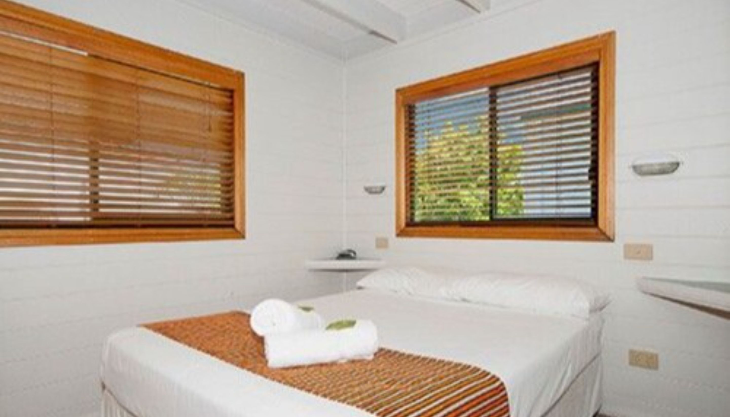Ein Schlafzimmer mit Bett, Fenster und Nachttisch.