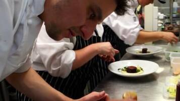 Chefs preparing dishes in a professional kitchen.