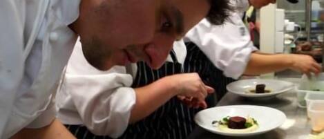 Chefs preparing dishes in a professional kitchen.