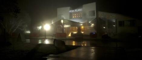A building with a sign reading "HIGH PLAINS" at night.