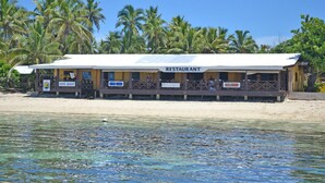 A beachfront restaurant with a sign indicating it offers seafood. - Ratu Kini Backpackers & Dive Resort (Mana Island)