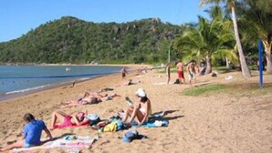 A beach with people sunbathing and swimming. - Magnetic Sunsets Resort (Horseshoe Bay)