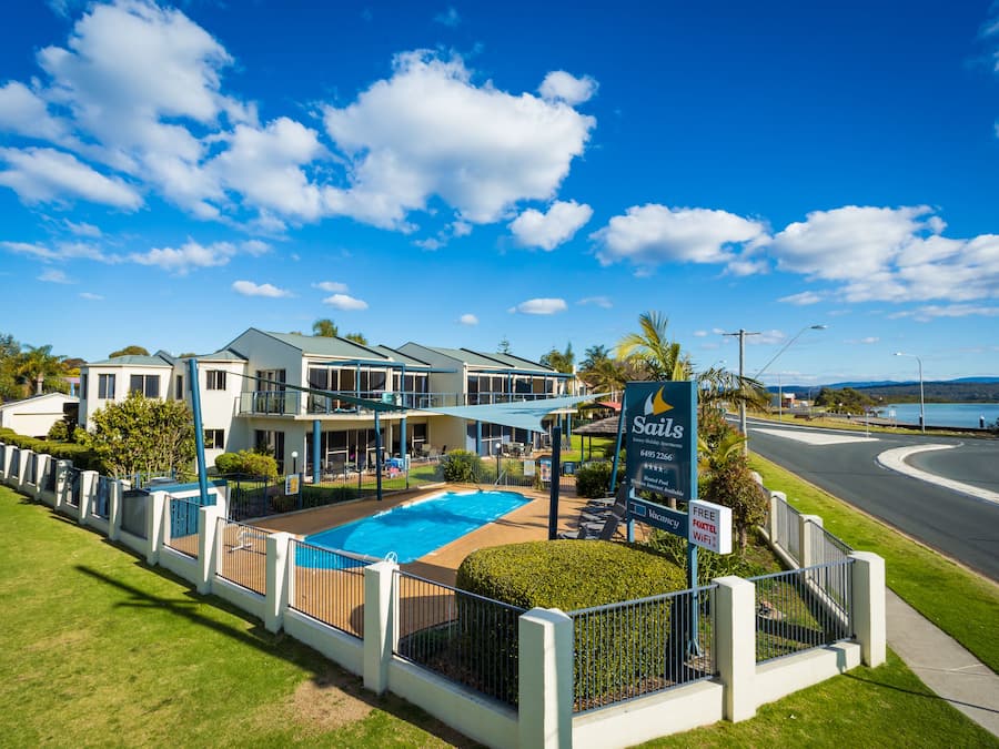 Ein Hotel mit Schwimmbad, Schild mit kostenlosem WLAN und Blick auf das Wasser.