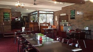 Interior de restaurante con paredes de ladrillo, muebles de madera y una zona de bar.