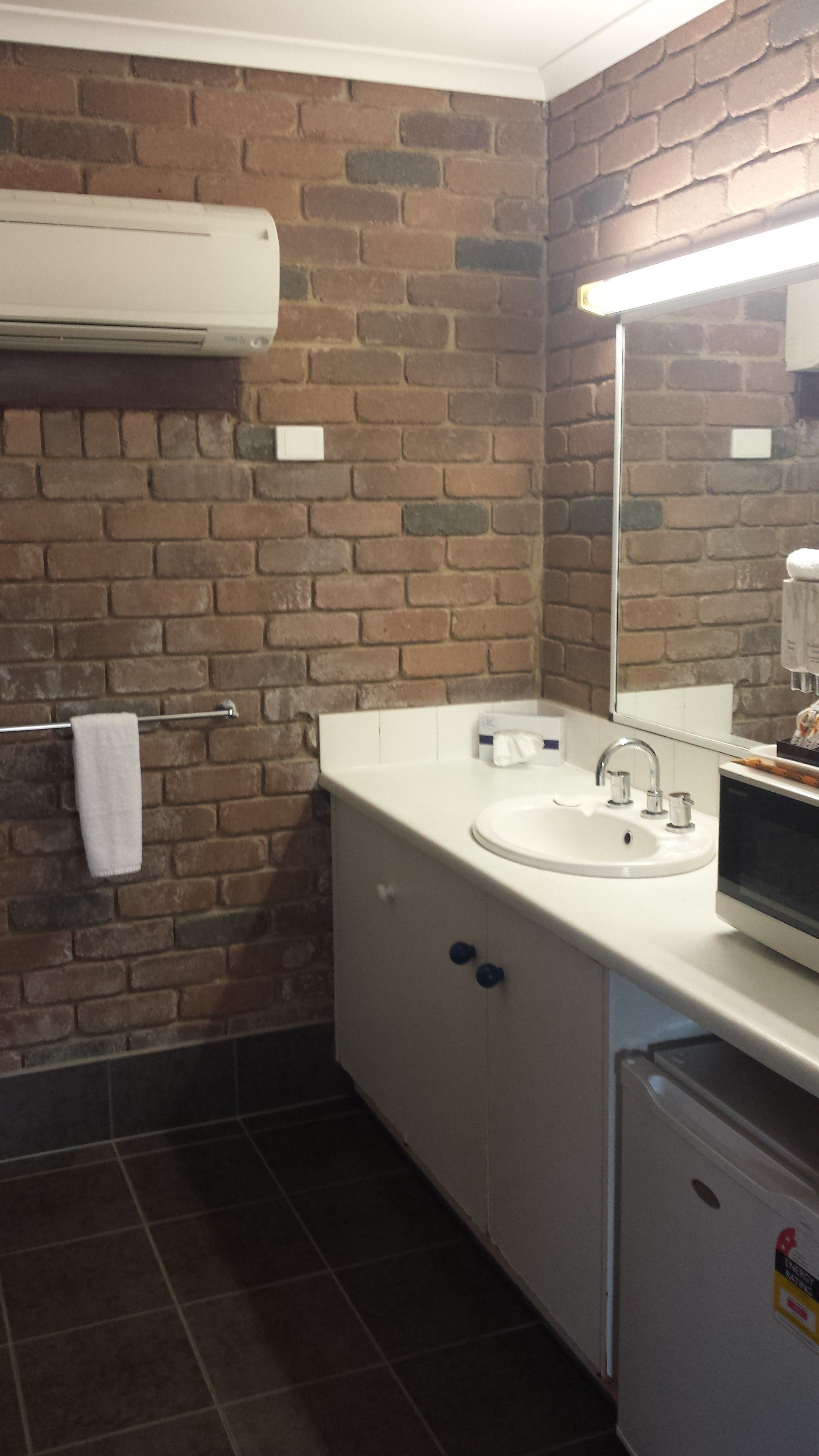 A bathroom with a white sink, a mirror, and a towel rack.