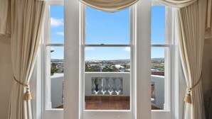 A room with a large window, curtains, and a view of a cityscape. - Waratah on York (Launceston)