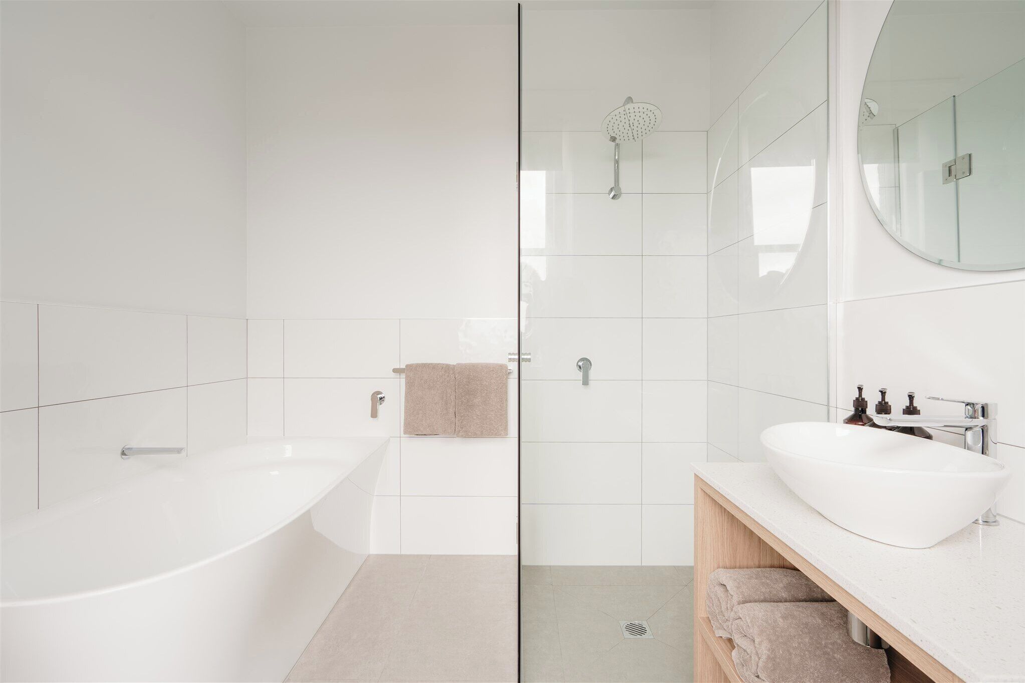 A modern bathroom with a freestanding bathtub, a glass-enclosed shower, and a vanity with a sink and mirror.