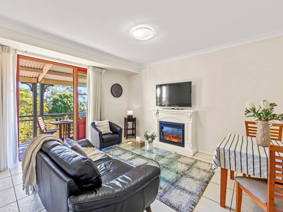 Una sala de estar con chimenea, televisor, mesa de comedor y sofá.