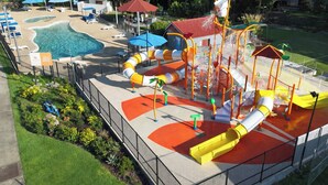 Parque aquático com toboáguas, piscina e espreguiçadeiras.