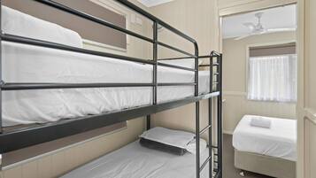 A bunk bed room with a single bed on the right and a lower bunk bed on the left.