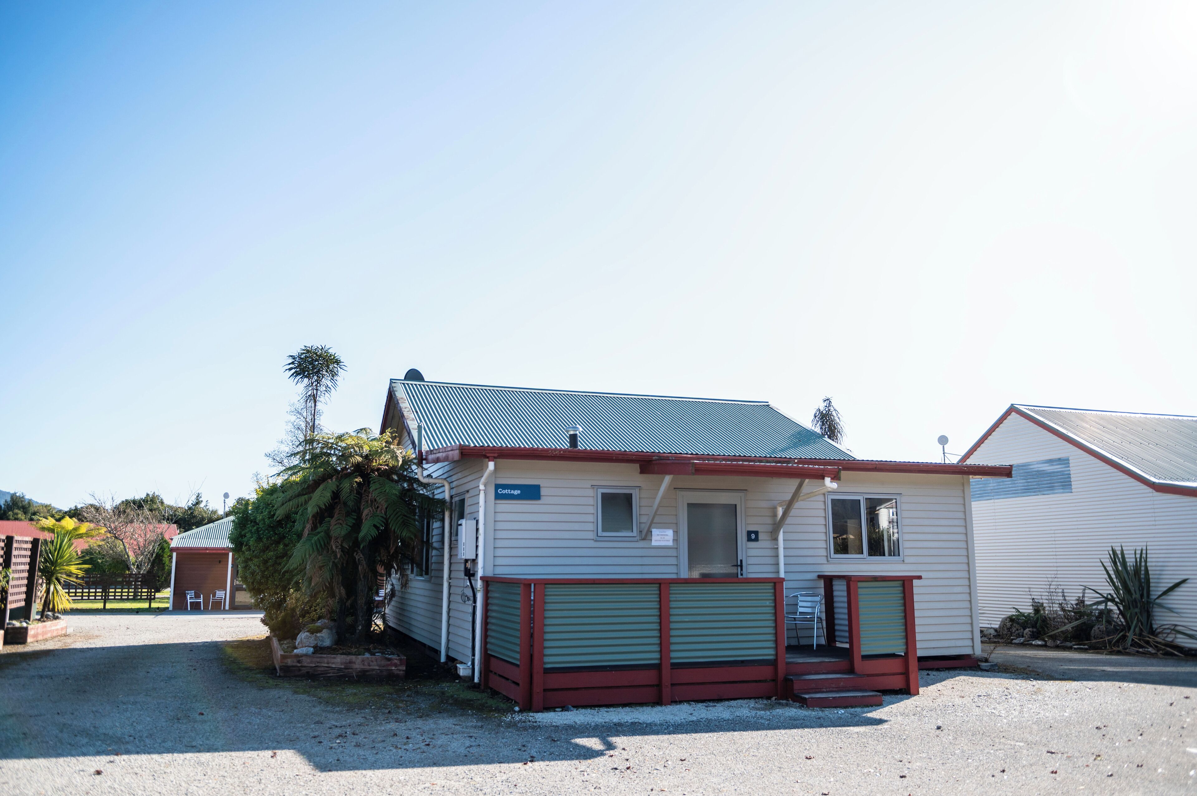 A small, single-story building with a metal roof, a front porch, and a sign labeled "Cottage."