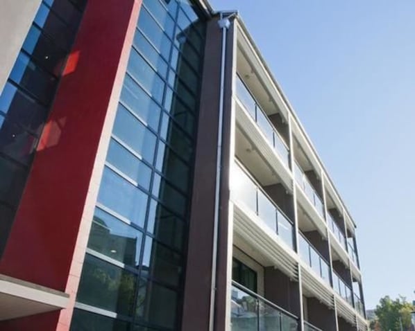A modern building with large windows and a red accent wall. - 315 Euro Motel & Serviced Apartments (Dunedin)