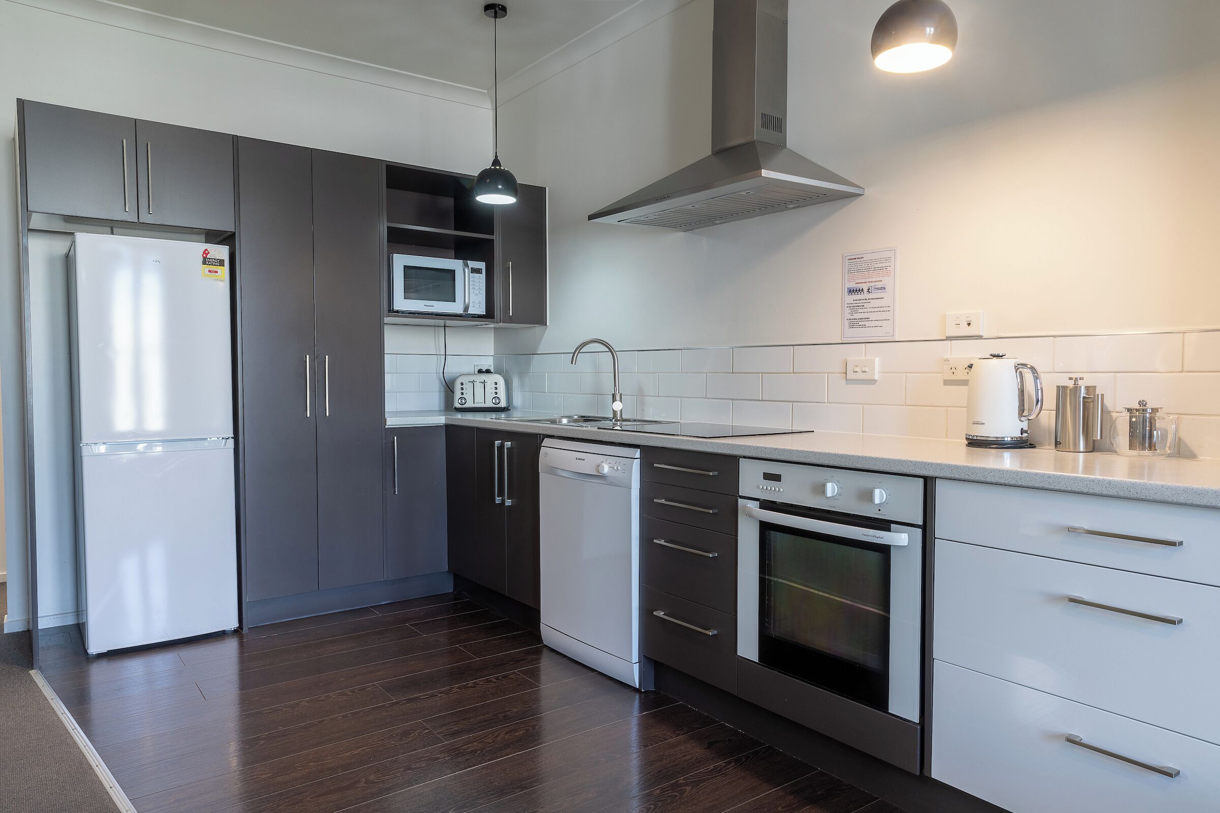 Una cocina moderna equipada con refrigerador, microondas, lavavajillas, horno y cafetera.