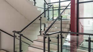 A modern staircase with glass railings and checkered flooring. - 315 Euro Motel & Serviced Apartments (Dunedin)