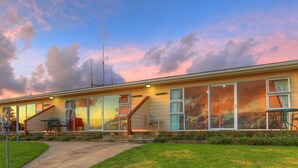 A modern house with large windows and a covered patio area. - Islander Lodge Apartments (Norfolk Island)