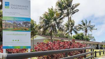 A sign for Daydreamer Apartments with contact information and a website URL.