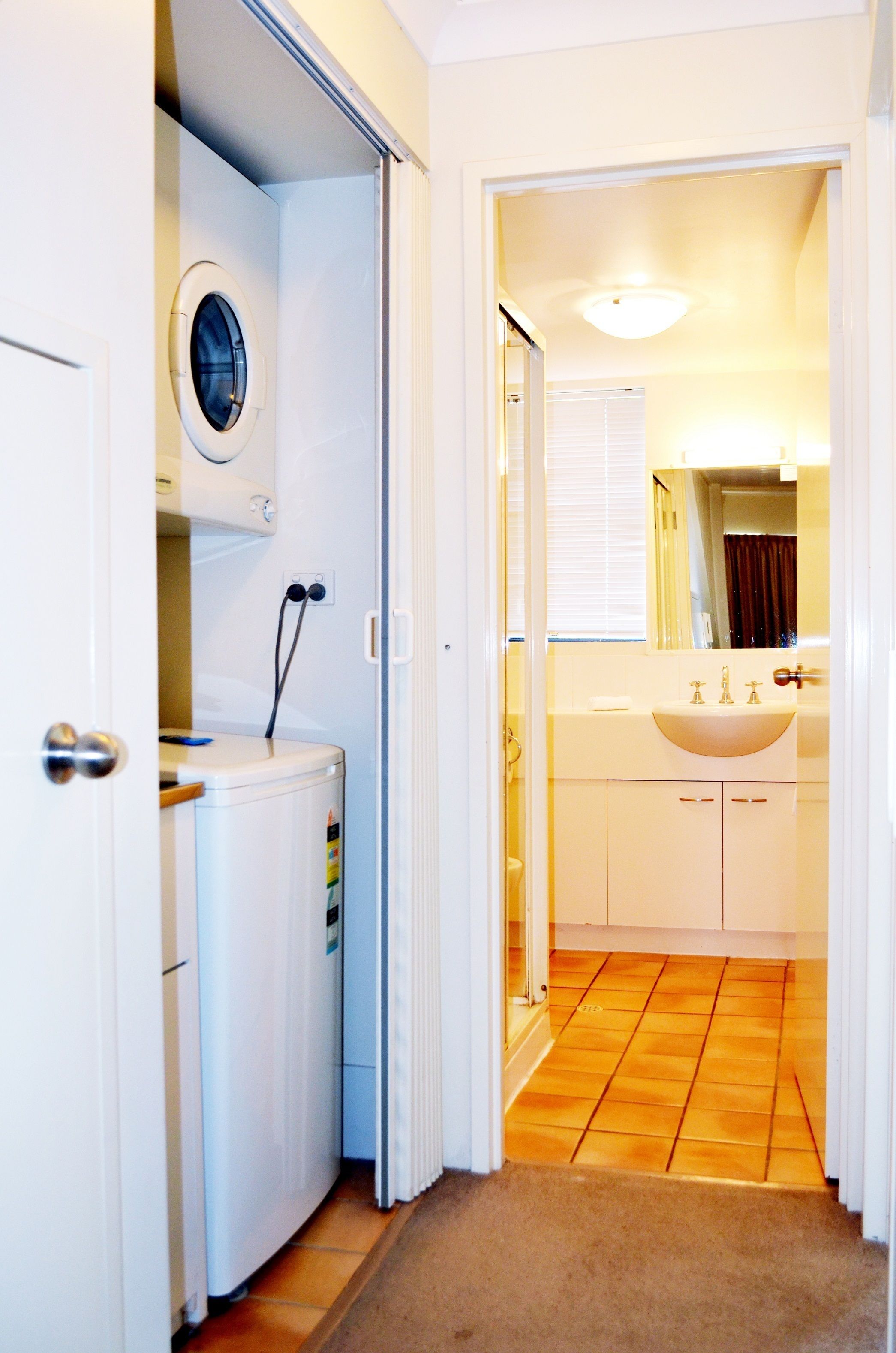 A compact bathroom with a toilet, sink, and mirror.