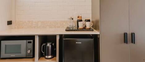 Una cocina compacta equipada con microondas, cafetera y un refrigerador Hisense.