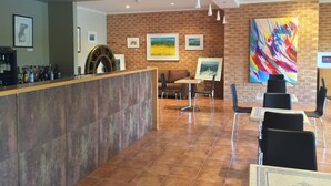Un espace d’accueil avec un comptoir, des sièges et des œuvres d’art accrochées aux murs.