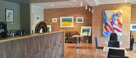A reception area with a counter, seating, and artwork on the walls.