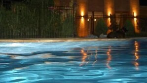 Une piscine avec un bâtiment en arrière-plan.