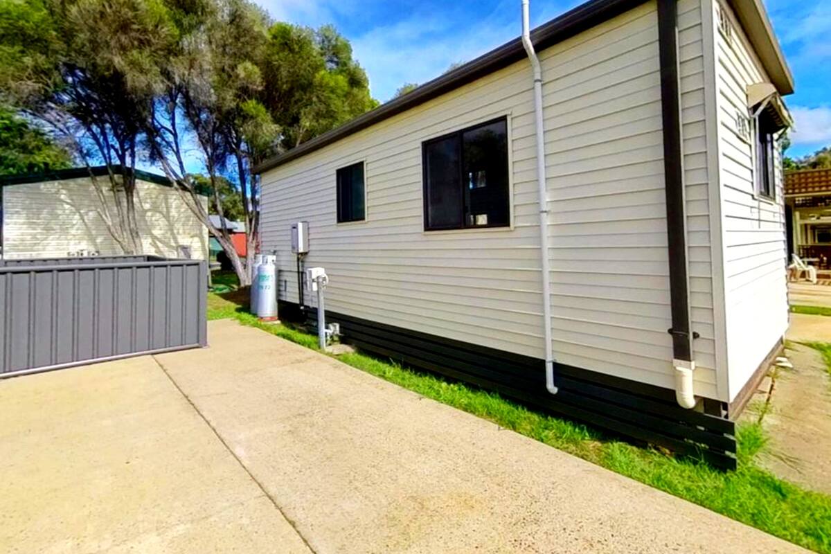 A single-story mobile home with a small front porch and a covered patio area.