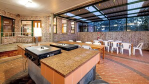 Ein Restaurant mit Backsteinwand, überdachtem Außenbereich und einer Theke mit Spüle.