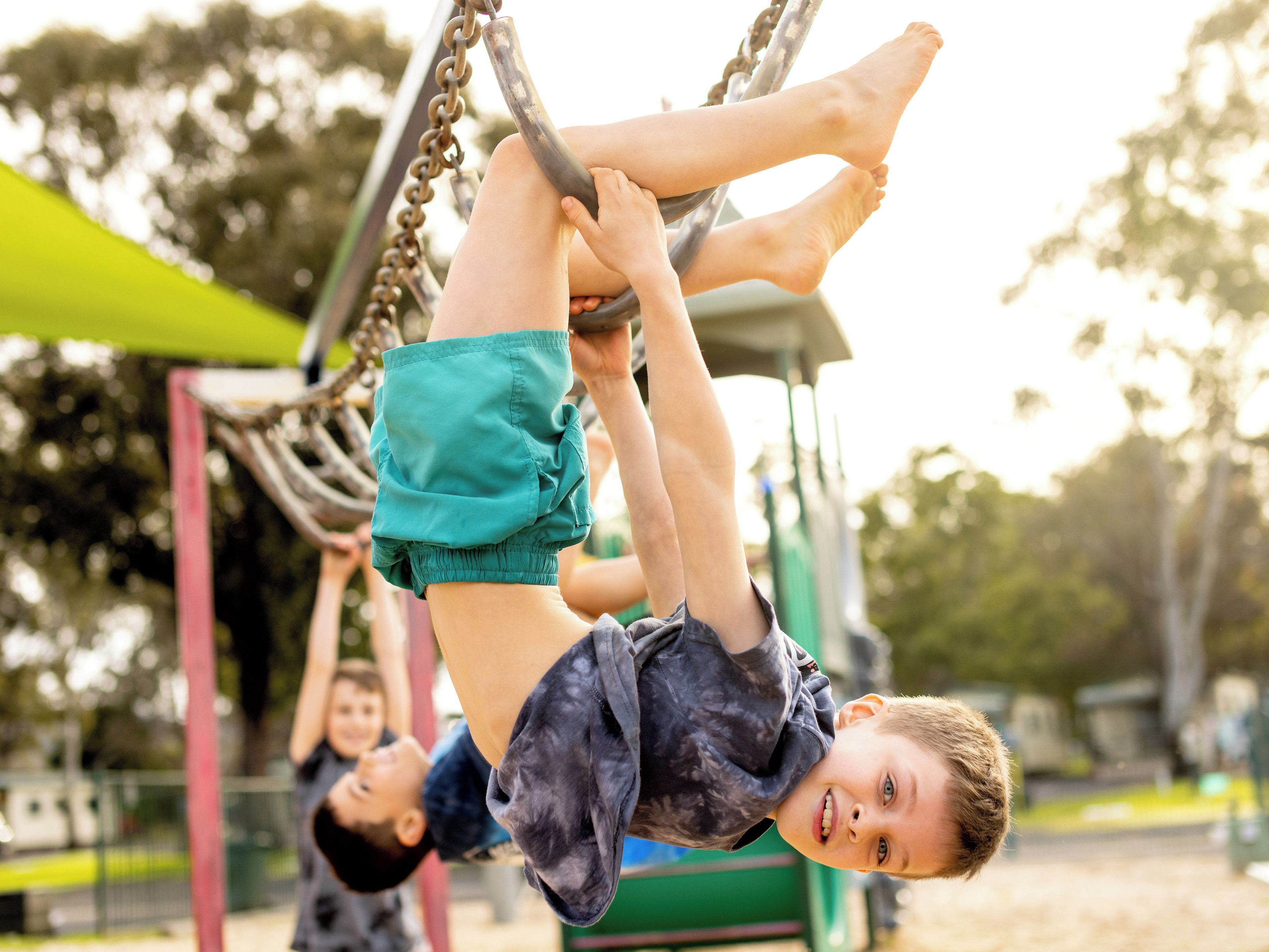 A child swinging on a playground structure.
