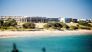 A coastal hotel with multiple buildings, a sandy beach, and a view of the ocean. - Onshore Torquay (Torquay)