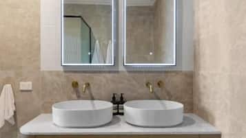 Un baño con dos lavamanos, un espejo y un mueble de madera.