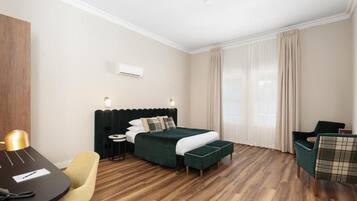 Ein Hotelzimmer mit Bett, Schreibtisch, Stuhl und einem kleinen Tisch.