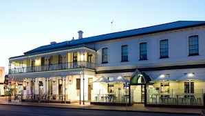 A historic building with a balcony and outdoor seating area.